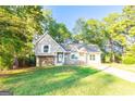 Charming home featuring stone and vinyl siding, complemented by a well-maintained lawn and mature trees at 8500 Bowen Ct, Jonesboro, GA 30238