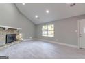 Spacious living room boasts a vaulted ceiling, stone fireplace, recessed lighting and light wood floors at 8500 Bowen Ct, Jonesboro, GA 30238