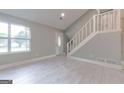 Inviting living room features new light floors, fresh paint, staircase and view of front yard at 8500 Bowen Ct, Jonesboro, GA 30238
