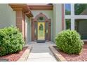 The home's inviting entrance features a walkway lined with lush greenery and a bright yellow door at 411 Baneberry Bnd, Peachtree City, GA 30269
