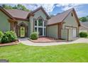 Beautiful exterior with a well-kept lawn and landscaped garden beds accenting the home's entrance at 411 Baneberry Bnd, Peachtree City, GA 30269