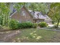 Attractive brick home features a manicured lawn, mature trees, and attached garage at 886 Pine Needle Rd, Hampton, GA 30228