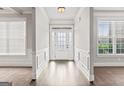 Bright foyer with hardwood floors, white trim, and ample natural light from the glass front door at 162 Aylesbury Blvd, Mcdonough, GA 30252
