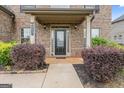 Inviting front porch showcasing a brick facade, manicured shrubs, and a stylish front door at 162 Aylesbury Blvd, Mcdonough, GA 30252