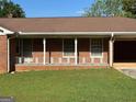 Close up shot of a charming single-story brick home with a quaint front porch at 18 North Ave, Hampton, GA 30228