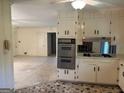 View of a kitchen featuring classic appliances, white cabinets, and a cozy eating area at 18 North Ave, Hampton, GA 30228