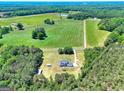 Panoramic aerial view showcases the home's expansive property surrounded by lush greenery and wooded areas at 1621 Dixie Rd, Covington, GA 30014