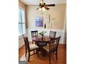 Cozy dining room with wood floors, ceiling fan, and a round wooden table with four chairs at 511 Bonneset Ct, Canton, GA 30114