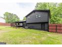 Side view of home from the backyard showing dark siding, covered deck and fenced yard at 870 The Cir, Lawrenceville, GA 30043