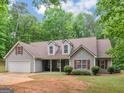 Charming single-story home features gray siding, brown roof and attached two-car garage at 445 Royal St, Mcdonough, GA 30253