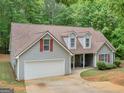 Charming single-story home features gray siding, brown roof and attached two-car garage at 445 Royal St, Mcdonough, GA 30253