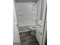 Tiled shower and bathtub combo with white cabinetry, and modern fixtures at 324 Cynthia Ct, Jonesboro, GA 30238