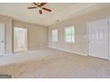 Large main bedroom with tray ceiling, plush carpeting, two windows, and ensuite access at 126 Usher Ln, Covington, GA 30016