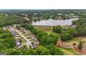 Aerial view of a community with houses and a lake at 416 Clarion Dr, Carrollton, GA 30116