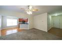Open concept living room with hardwood, carpet flooring, a ceiling fan, and kitchen view at 416 Clarion Dr, Carrollton, GA 30116
