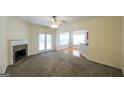 Spacious living room with fireplace, ceiling fan, access to kitchen and a set of glass doors at 416 Clarion Dr, Carrollton, GA 30116