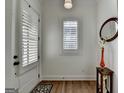 Bright and airy foyer with hardwood floors, white door with window shutters, and decorative accessories at 1006 Fendley St, Woodstock, GA 30188