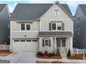 Charming two-story home with a front-facing garage, beautifully landscaped yard, and craftsman style windows at 1006 Fendley St, Woodstock, GA 30188