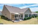 A covered patio with an outdoor dining area set in the private backyard at 100 Maple Leaf Rd, Sharpsburg, GA 30277