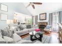 Bright living room with a stone fireplace, vaulted ceilings, and open access to the dining area at 1211 Fly Rod Ln, Loganville, GA 30052