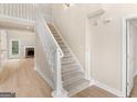 View of the home's staircase with white railings, carpeted steps, and an inviting entrance area at 30 Stonewall Dr, Covington, GA 30016