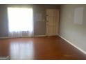 Bright living room featuring wood floors, a window with sheer curtains, and a neutral wall color at 1028 Dixie Dr, Jonesboro, GA 30236