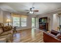 Comfortable living room with wood-look flooring, ceiling fan, and a large window providing natural light at 357 Oak Hill Rd, Covington, GA 30016