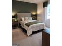 Inviting bedroom featuring a queen bed, accent wall, and modern decor at 613 Elsa Lane # 77, Mcdonough, GA 30252