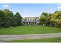 Charming exterior view of the property, featuring a sprawling lawn and mature trees at 885 Kelleytown Rd, Mcdonough, GA 30252