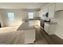 Modern kitchen with white cabinets, granite countertops, and stainless steel appliances at 2051 Blue Sky Ave, Covington, GA 30016