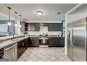 Modern kitchen with stainless steel appliances, dark cabinetry, and stylish tile flooring at 203 Brannan Rd, Mcdonough, GA 30253