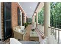 Relaxing outdoor porch featuring wicker furniture and a view of the surrounding greenery at 9274 Betony Wood Trl, Jonesboro, GA 30236