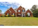 Attractive two-story brick home with manicured lawn, black shutters, and lush landscaping at 208 Summer Chase, Carrollton, GA 30116
