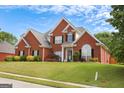 Charming two-story brick home featuring an immaculate lawn and mature landscaping at 208 Summer Chase, Carrollton, GA 30116