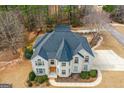 Aerial shot of a brick home with an attached trampoline featuring a well-maintained roof and spacious surroundings at 1202 Persimmon Way, Mcdonough, GA 30252