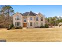 Stately two-story home with a brick exterior, many large windows, and a sprawling front yard at 1202 Persimmon Way, Mcdonough, GA 30252