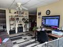 Comfortable living room with ceiling fan, television with sports and decorative collectibles lining the shelves at 2195 Wilson Nw Rd, Conyers, GA 30012