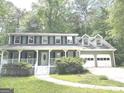 Beautiful two-story home with a front porch and a two-car garage, nestled amongst trees at 305 Glenloch Ln, Stockbridge, GA 30281