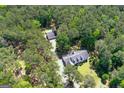Aerial view of a charming home surrounded by lush greenery, with a detached garage and ample yard space at 3499 S Ola Rd, Locust Grove, GA 30248