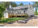 Back exterior featuring a deck, well maintained lawn, and a three car garage at 3499 S Ola Rd, Locust Grove, GA 30248