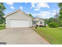 Inviting one-story home features a two-car garage, manicured lawn, and well-placed shrubs, with vinyl siding at 1704 New Hope Rd, Locust Grove, GA 30248