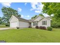 Well-kept home with a two-car garage, green lawn, vinyl siding, and fresh landscaping at 1704 New Hope Rd, Locust Grove, GA 30248