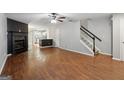 Spacious living room with hardwood floors, a fireplace, and a ceiling fan open to the kitchen at 1823 Devon Sw Dr, Atlanta, GA 30311