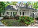 Beautiful home featuring a charming porch, black shutters, and colorful landscaping at 2058 Sewanee Ct, Villa Rica, GA 30180