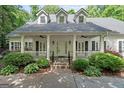 Welcoming front porch with white columns, dual ceiling fans, and lush landscaping at 2058 Sewanee Ct, Villa Rica, GA 30180