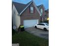 This is a two-story brick home with a two-car garage and manicured front lawn at 10937 Southwood Dr, Hampton, GA 30228