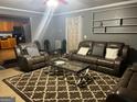 A cozy living room with a brown leather sofa set, patterned rug, and modern decor at 10937 Southwood Dr, Hampton, GA 30228