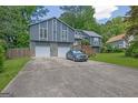 Two-story home showcases a gray exterior, stone accents, two-car garage, and a well-maintained driveway with ample parking at 2673 Deerfield Sw Cir, Marietta, GA 30064