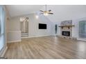 Bright living room featuring a stone fireplace, high ceilings, modern ceiling fan, and plenty of natural light at 2673 Deerfield Sw Cir, Marietta, GA 30064