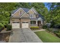 Inviting brick home showcasing a manicured lawn, two-car garage, and covered front porch at 770 River Cove Dr, Dacula, GA 30019